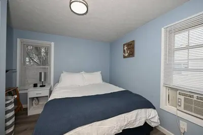a blue bedroom with a bed and a window at Recharge & Reconnect Your cozy Vermilion nest in Vermilion