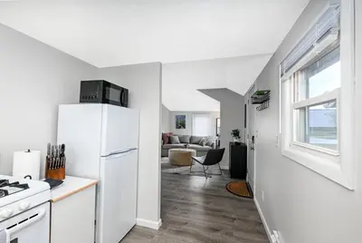 a kitchen with a white refrigerator and a living room at Recharge & Reconnect Your cozy Vermilion nest in Vermilion