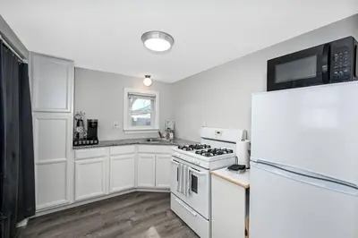 a white kitchen with a stove and a refrigerator at Recharge & Reconnect Your cozy Vermilion nest in Vermilion