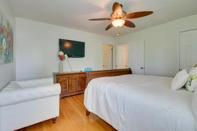 a bedroom with a white bed and a ceiling fan at Home with Hot Tub and Deck about 3 Mi to Ark Encounter! in Williamstown