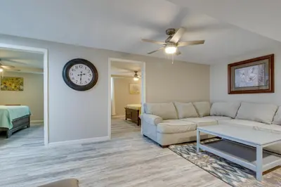 a living room with a couch and a clock on the wall at Home with Hot Tub and Deck about 3 Mi to Ark Encounter! in Williamstown