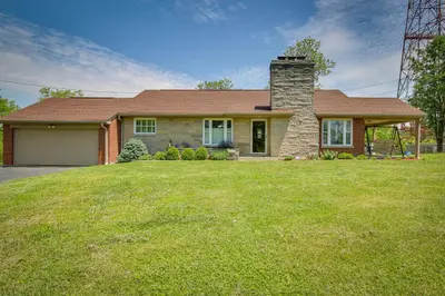 a house with a grassy yard in front of it at Home with Hot Tub and Deck about 3 Mi to Ark Encounter! in Williamstown