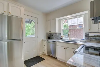 a kitchen with white cabinets and a sink and a window at Pet-Friendly Cincinnati Retreat with Hot Tub in Blue Ash