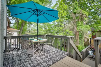 a patio with a table and a blue umbrella at Pet-Friendly Cincinnati Retreat with Hot Tub in Blue Ash