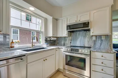 a kitchen with white cabinets and a sink and an oven at Pet-Friendly Cincinnati Retreat with Hot Tub in Blue Ash