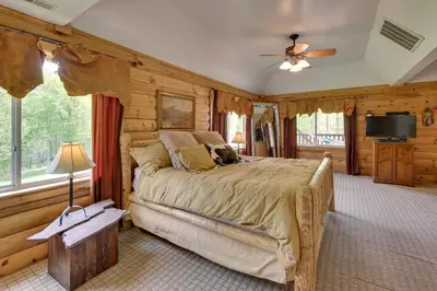 a bedroom with a large bed and a television at Fraziers Bottom Cabin on 800 Acres of Land with Lake in Fraziers Bottom