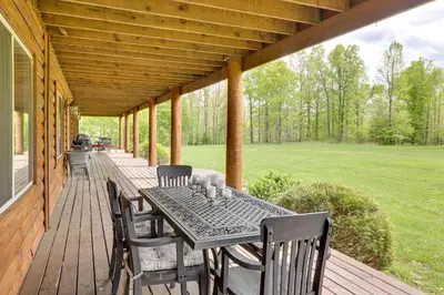 a wooden porch with a table and chairs on it at Fraziers Bottom Cabin on 800 Acres of Land with Lake in Fraziers Bottom