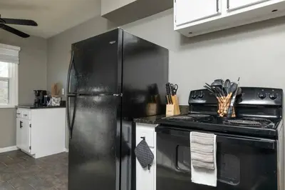 a kitchen with a black refrigerator and a stove at Parma Home w/ Hot Tub and Arcade room! in Parma