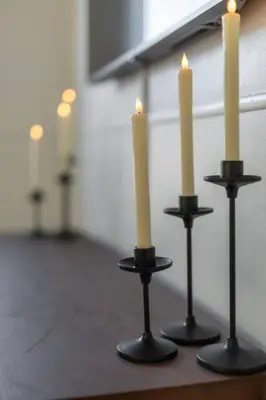 three white candles on black candlesticks on a table at Parma Home w/ Hot Tub and Arcade room! in Parma