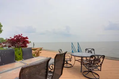a patio with tables and chairs and the ocean at Waterfront Luna Pier Home 14 Mi to Downtown Toledo in Erie