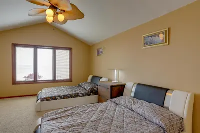 a bedroom with two beds and a ceiling fan at Waterfront Luna Pier Home 14 Mi to Downtown Toledo in Erie
