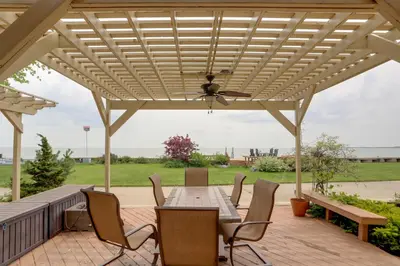 a wooden pergola with a table and chairs on a deck at Waterfront Luna Pier Home 14 Mi to Downtown Toledo in Erie