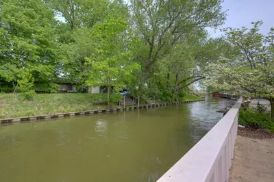 a bridge over a river with trees and grass at Waterfront Luna Pier Home 14 Mi to Downtown Toledo in Erie
