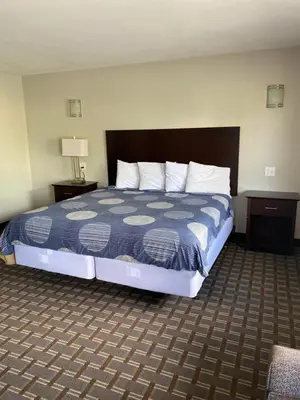 a hotel room with a bed and two night stands at New Budget Inn in Eaton