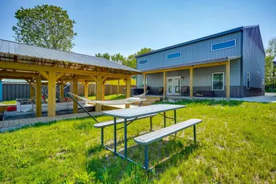 a picnic table and benches in front of a building at Waterfront Buckeye Lake Vacation Rental with Hot Tub in Hebron