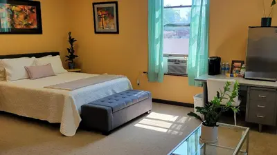 a bedroom with a bed and a tv and a window at Upstage Stay in Bainbridge