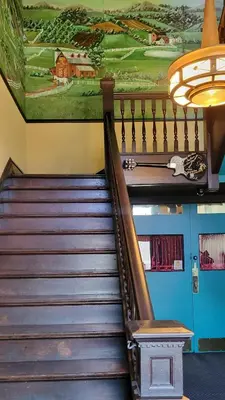 a staircase in a building with a painting on the wall at Upstage Stay in Bainbridge