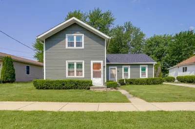 a gray house with a white door in a yard at Cozy Norwalk Apt Near Cedar Point and Kalahari! in Norwalk