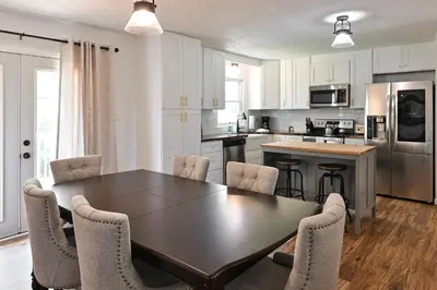 a kitchen with a dining room table and chairs at 3BR Home for 8 - Only 5 Minutes to Ark - Foosball in Williamstown