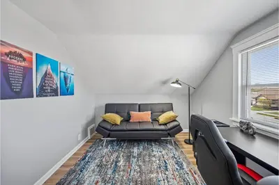 a living room with a black leather couch and a window at Amazing Parma Home King Bed Full Office Room in Parma