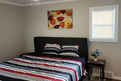 a bed in a bedroom with a painting on the wall at Beautiful 4 bedroom in Cleveland in Euclid