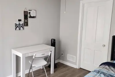 a white desk with a chair in a bedroom at Beautiful 4 bedroom in Cleveland in Euclid