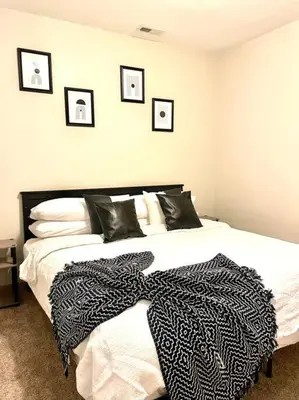a bedroom with a black and white blanket on a bed at The KING Apt in Downtown Columbus in Columbus