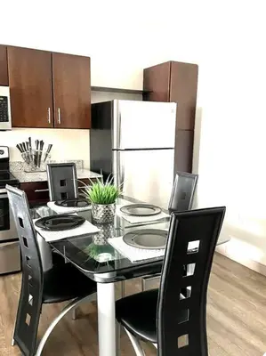 a kitchen with a table with chairs and a refrigerator at The KING Apt in Downtown Columbus in Columbus