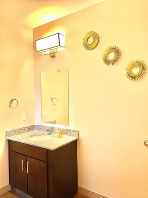 a bathroom with a sink and two mirrors on the wall at King & Queen in Downtown Columbus in Columbus