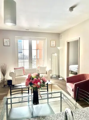 a living room with a vase of flowers on a glass table at King & Queen in Downtown Columbus in Columbus