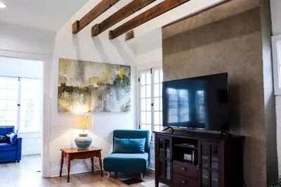 a living room with a blue chair and a television at Downtown Retreat - 2BR Oasis in Columbus