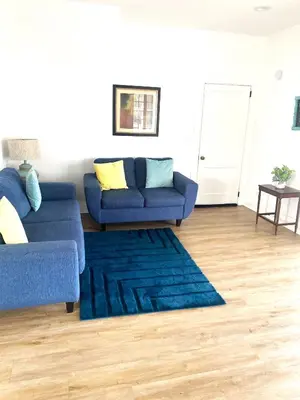 a living room with a blue couch and a rug at Downtown Retreat - 2BR Oasis in Columbus