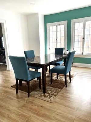 a dining room with a wooden table and blue chairs at Downtown Retreat - 2BR Oasis in Columbus