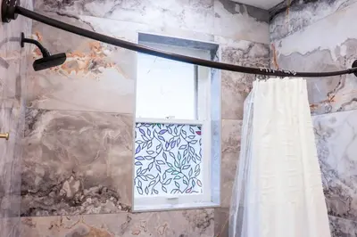 a shower curtain in a bathroom with a window at Downtown Retreat - 2BR Oasis in Columbus