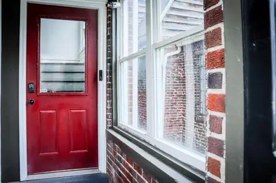 a red door on a brick building with a window at Downtown Retreat - 2BR Oasis in Columbus