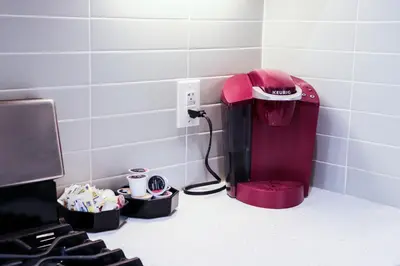 a red coffee maker in a kitchen next to a stove at Downtown Retreat - 2BR Oasis in Columbus