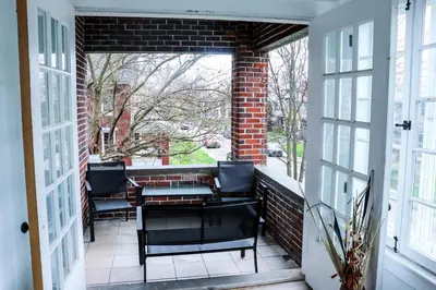 a balcony with chairs and a table on a brick wall at Downtown Retreat - 2BR Oasis in Columbus
