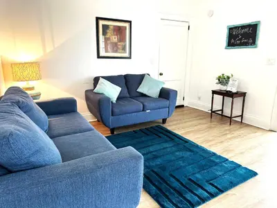 a blue couch and a chair in a living room at Downtown Retreat - 2BR Oasis in Columbus