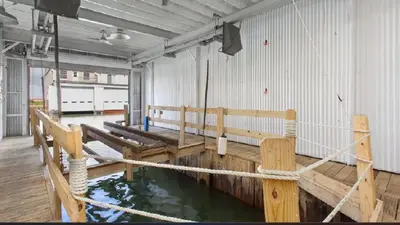 a room with wooden benches and water in it at Beautiful Boathouse overlooking the Bay in Sandusky