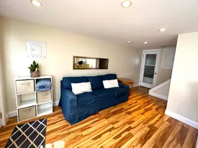 a living room with a blue couch and wooden floors at Beautiful Boathouse overlooking the Bay in Sandusky