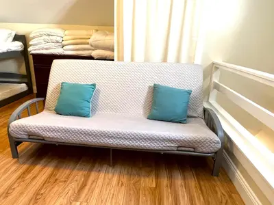 a bench with two blue pillows on it in a room at Beautiful Boathouse overlooking the Bay in Sandusky