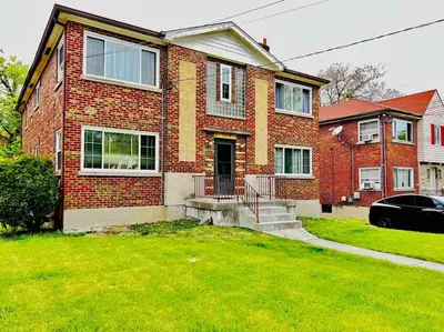 a brick house with a car parked in front of it at Red Ruby Spacious 2 Bedroom Apt 10 Minutes to Dwntwn in Cincinnati