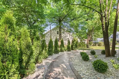 a garden with trees and a house in the background at The Luxe/Hot Tub/12min to Horse Park/30 Min to Ark in Georgetown