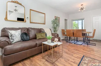 a living room with a brown couch and a table at Amazing Downtown Views - 3 Minutes to Downtown! in Cincinnati