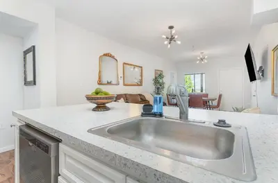 a kitchen with a sink and a living room at Amazing Downtown Views - 3 Minutes to Downtown! in Cincinnati