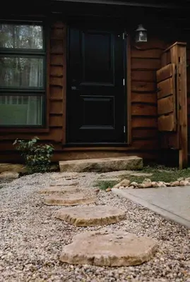 a door of a house with stepping stones in front of it at Lake with Dock and Hot Tub Hocking Hills Cabin in Rockbridge