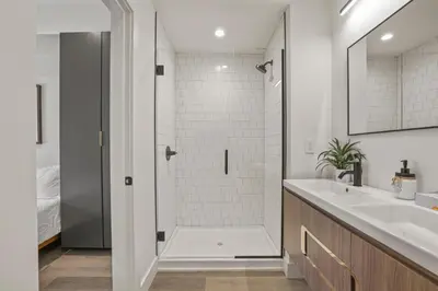 a white bathroom with a shower and a sink at Chic Retreats in Columbus in Columbus