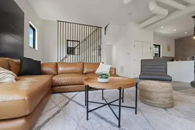 a living room with a brown leather couch and a table at Chic Retreats in Columbus in Columbus