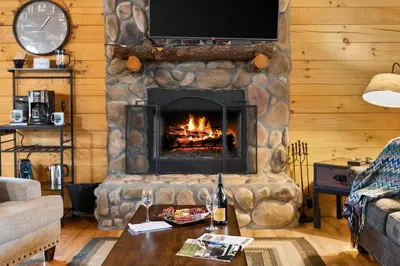 a living room with a stone fireplace with a tv at The Lookout in Logan