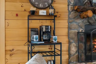 a room with a fireplace and a shelf with two coffees at The Lookout in Logan